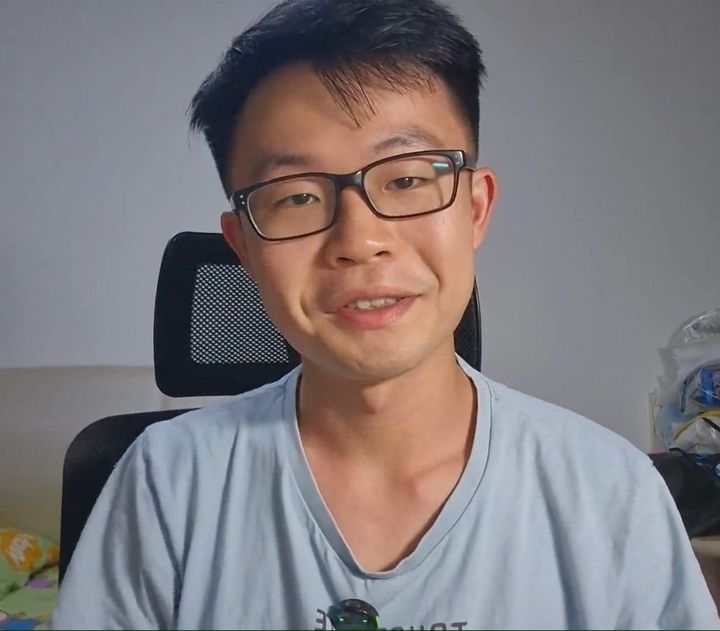 Chuan Long smiling at his desk